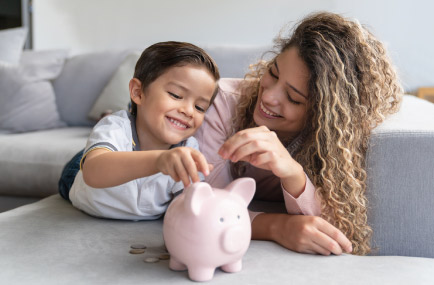 mom child putting money into a piggy bank